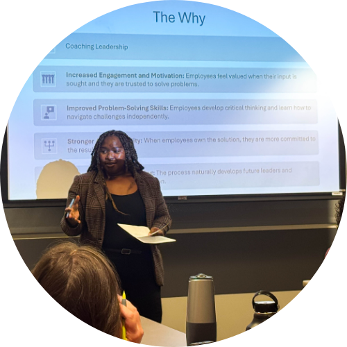 A speaker leads a coaching session on leadership, emphasizing the benefits of employee engagement and problem-solving skills.